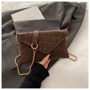 Vue détaillée du sac enveloppe léopard marron avec chaîne dorée et fermoir circulaire