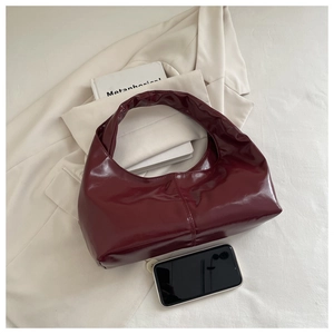Glossy burgundy leather hobo bag styled with an off-white blazer and fashion books