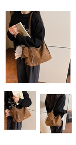 Detail view of large brown suede bucket bag with fringe tassels and side pouch accessories
