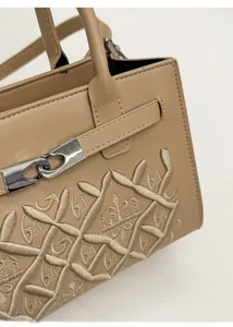 Gros plan détaillé sur le sac en cuir beige avec broderie GA et fermoir métallique argenté