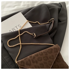 Détail du sac bandoulière léopard en daim avec chaîne dorée et rabat enveloppe