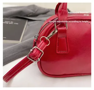 Detail of red bowling bag showing silver metal buckles and adjustable shoulder strap attachment