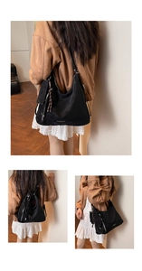 Macro view of large black faux suede tote bag featuring a small zipper coin pouch detail