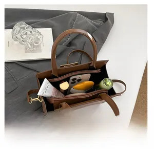 Top view of brown leather bag interior showing spacious compartments with essentials
