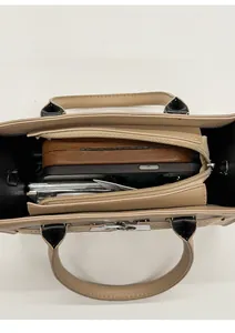 Intérieur spacieux d'un sac à main kaki montrant les compartiments et objets quotidiens