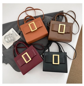 Flat lay of small square crossbody bags in four colors with large gold buckles