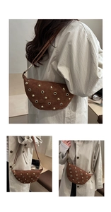 Detail du sac demi-lune en daim marron avec rivets dores et oeillets metalliques