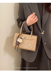 Détail du sac à main kaki brodé avec fermoir métallique et accessoire en peluche