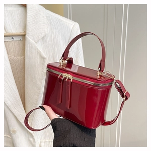 Dettaglio della borsa in pelle verniciata rosso scuro con doppia cerniera dorata