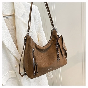 Macro shot of brown frosted leather hobo bag texture with silver zipper and knot detail