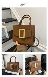 Detailed view of brown leather square handbag with iconic large gold buckle design