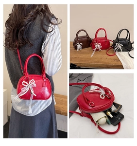 Détail du petit sac carré avec noeud perlé, charmes en dentelle et vue sur la capacité