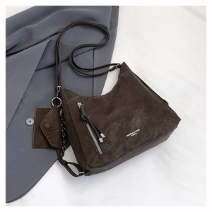 Detail of dark coffee vintage matte tote bag with fringe zippers on a blue blazer