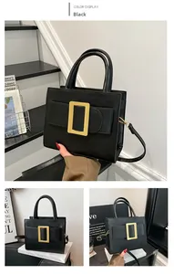 Detail of black faux leather handbag featuring a large gold rectangular metal buckle