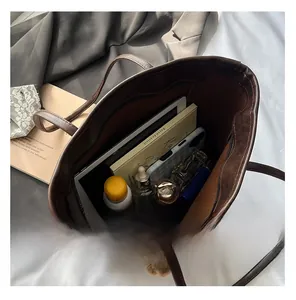 Top view of a large brown tote bag showing its spacious interior with books and a tablet