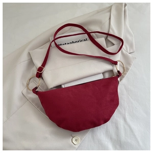 Détails d'un sac demi-lune en daim bordeaux avec de grands anneaux métalliques dorés