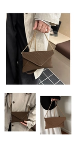 Detailed macro view of brown envelope bag with woven leather texture and gold chain strap