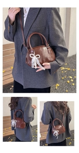 Détail du sac à main en cuir marron brillant avec charm en perles et dentelle élégant