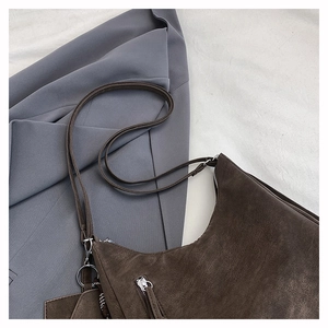 Detail shot of vintage dark brown matte leather texture and long metal zipper on shoulder bag