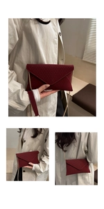 Close-up of wine red envelope bag with geometric texture and golden chain strap