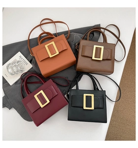 Detail of elegant handbags in four colors featuring a classic large gold metal buckle
