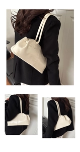 Detail of creamy white glossy leather shoulder bag with pleated texture and strap