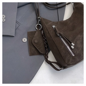 Detailed macro of dark brown retro leather texture with silver zipper and tassel accent