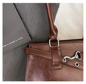 Detailansicht einer dunkelbraunen Lackledertasche mit hochwertigen silbernen Metallbeschlägen