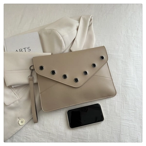 Close-up of beige envelope clutch with metal grommets and detachable wrist strap