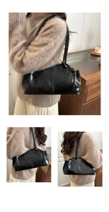 Detailed side view of black vintage leather underarm bag with elegant pleated design