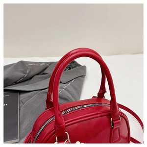 Vue détaillée du sac à main en cuir verni rouge avec fermeture éclair argentée