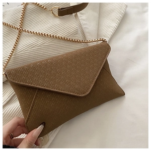 Close-up of brown envelope crossbody bag with woven texture and gold chain strap