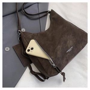 Detail of dark brown matte leather tote bag with functional front zipper pocket and phone slot