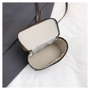 Detailed interior of the brown crossbody bag featuring chevron lining and golden zipper