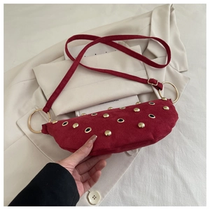 Détail du sac demi-lune en daim bordeaux avec rivets dorés et anneau métallique