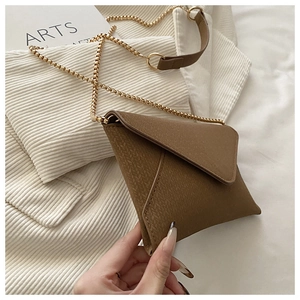 Close-up of dark brown woven texture envelope crossbody bag with gold chain strap