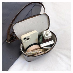 Spacious interior of dark patent leather crossbody bag with multiple daily essentials