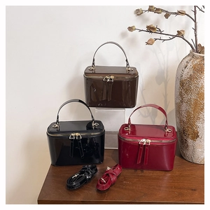 Close-up of elegant patent leather crossbody box bags in black, burgundy and brown colors