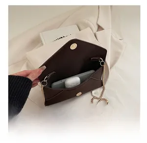 Internal view showing storage for smartphone and wireless earphones in brown chain bag