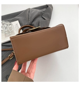 Detail of a dark brown leather bag showing rectangular base and fine stitching quality