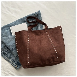 Detail of dark brown tote bag with silver metal studs and soft suede texture finish