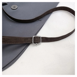 Detail of dark brown matte strap with silver metal buckle on a shoulder tote bag
