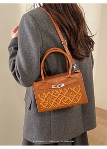 Détail du sac bandoulière vintage marron avec broderie couronne et fermoir rotatif argent
