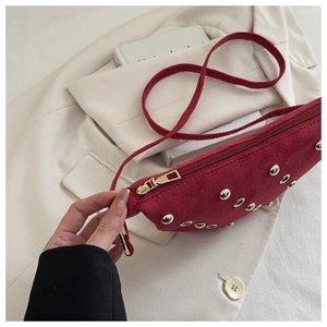 Détail du sac en daim bordeaux avec clous dorés et œillets métalliques rétro chic