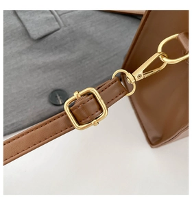Detail of premium brown leather texture with adjustable gold metal buckle and spring clasp