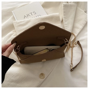Interior view of brown envelope chain bag showing capacity and gold magnetic closure