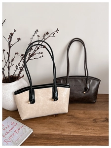 Detail of vintage tote bags in beige and brown PU leather with golden hardware