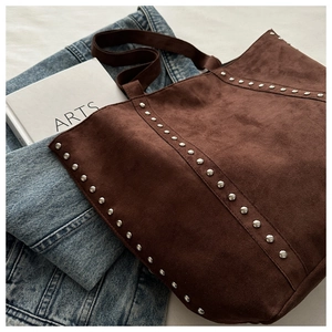 Detail of coffee brown suede tote bag with silver metal studs and durable top handle