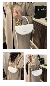 Detail of white saddle bag with unique gold metal handle and adjustable shoulder strap