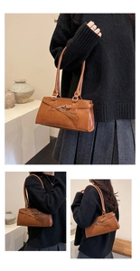 Detail der vintage karamellbraunen Baguette-Tasche mit Gürtelschnalle und Metallverschluss